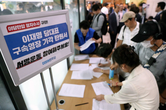 24일 진교훈 더불어민주당 서울 강서구청장 후보자 선거사무소 개소식에서 민주당 지지자들이 이재명 당대표 구속영장 기각 탄원서에 서명하고 있다.<공동취재·연합뉴스>